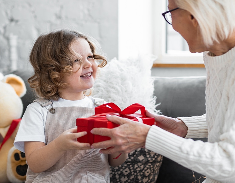 Djevojčica daje poklon svojoj baki za Božić