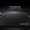 Samsung P9 Portable SSD, a dark gray rectangular external drive with a blue LED indicator strip, on a reflective black surface against a background of jagged dark crystal formations.